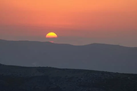 Sunset on the mountain, sun setting behind the mountain. Stock Photos