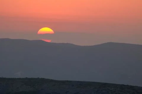 Sunset on the mountain, sun setting behind the mountain. Stock Photos