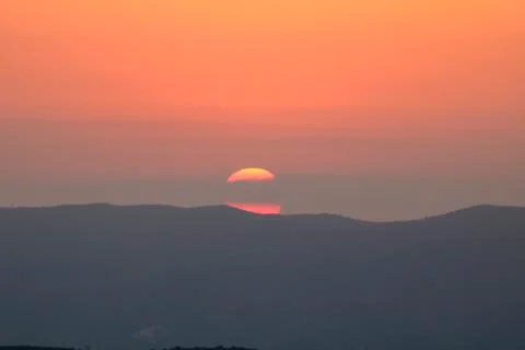 Sunset on the mountain, sun setting behind the mountain. Stock Photos