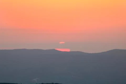 Sunset on the mountain, sun setting behind the mountain. Stock Photos