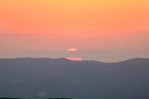 Sunset on the mountain, sun setting behind the mountain. Stock Photos