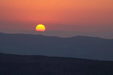 Sunset on the mountain, sun setting behind the mountain. Stock Photos