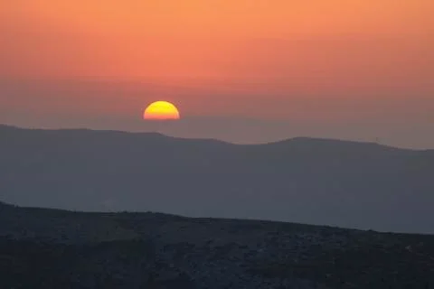 Sunset on the mountain, sun setting behind the mountain. Stock Photos