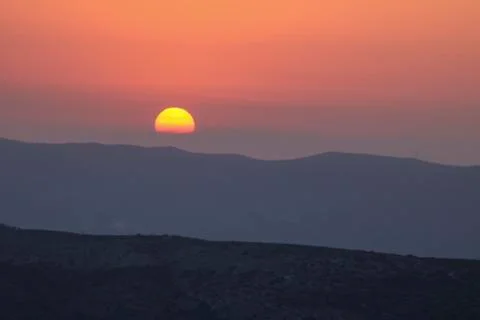 Sunset on the mountain, sun setting behind the mountain. Stock Photos