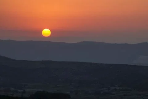 Sunset on the mountain, sun setting behind the mountain. Stock Photos