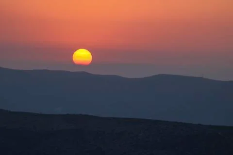 Sunset on the mountain, sun setting behind the mountain. Stock Photos