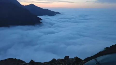 Sunset in a mountain valley densely covered with clouds Stock Footage 173429350