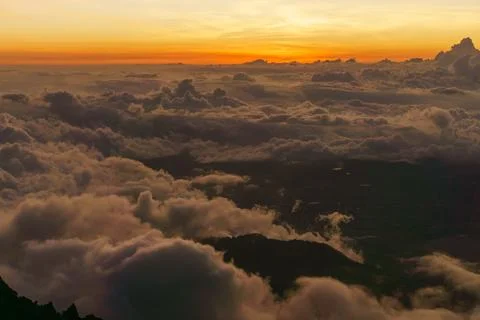 Sunset in the mountains above the clouds Stock Photos