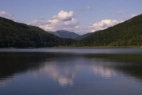 Sunset in the Mountains with Clouds and Reflection in the Lake Water Stock Photos