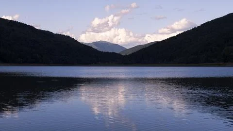 Sunset in the Mountains with Clouds and Reflection in the Lake Water Stock Photos