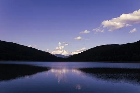 Sunset in the Mountains with Clouds and Reflection in the Lake Water Stock Photos