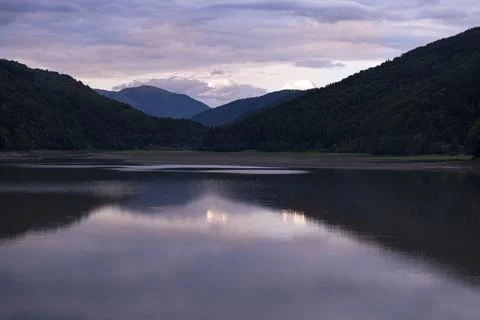 Sunset in the Mountains with Clouds and Reflection in the Lake Water Stock Photos