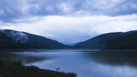 Sunset in the Mountains with Clouds and Reflection in the Lake Water Stock Photos