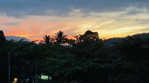 Sunset, mountains, palm trees and people walking along the road Stock Footage 233375940