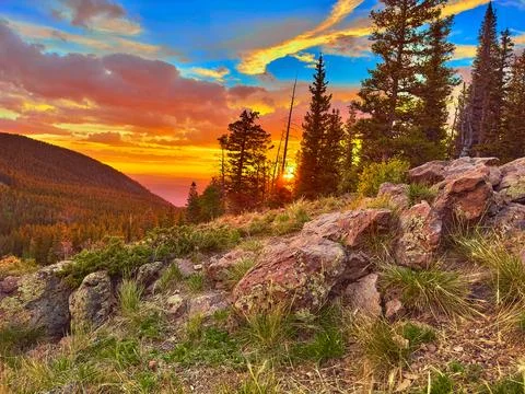 Sunset in the mountains with rocks in the foreground. Stock Photos