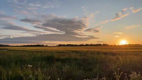 Sunset in nature. Field, clouds, horizon, blue sky with orange sunset in field. Stock Footage 268230624