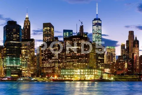 Sunset in New York City with a view of the illuminated skyline Stock Photos