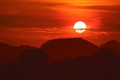 Sunset on night red sky back over silhouette tree mountain Stock Photos