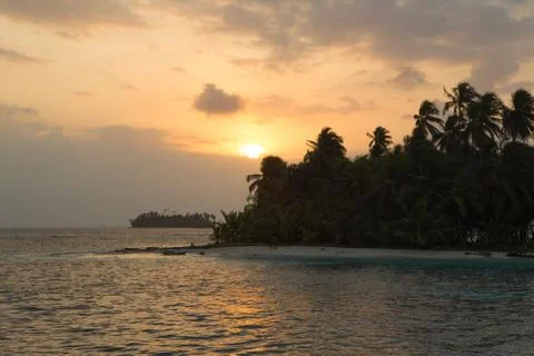Sunset, ocean and coconut trees near paradisiac island Stock Photos