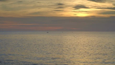Sunset ocean beach with beautiful waves and boat with paddling people Stock Footage 113271530