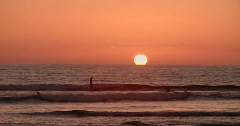 Sunset on the Ocean Horizon with Surfers Stock Footage 168741753