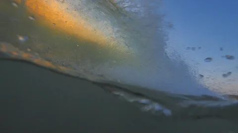 Sunset in the ocean with incoming waves  in slowmotion Stock Footage 90005907
