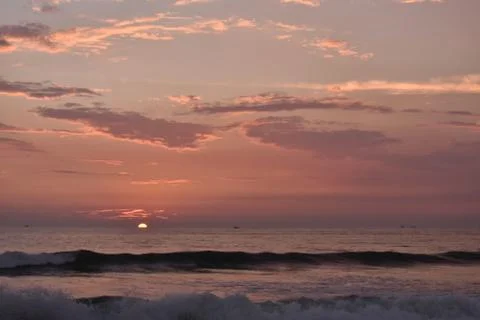 Sunset in a ocean with small waves Stock Photos