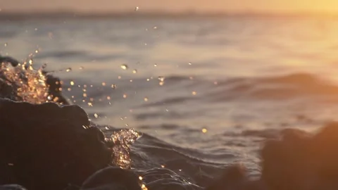 Sunset Ocean Waves Crashing on Rocky Shore With Golden Sunlight and Water Splash Stock Footage 337415013