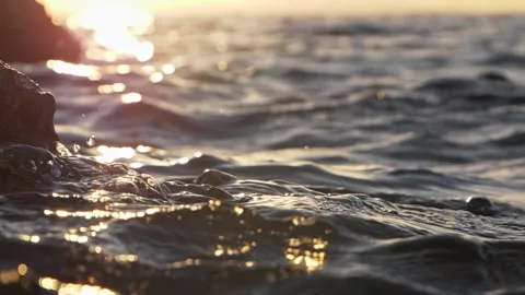 Sunset Ocean Waves Lapping Rocky Shoreline Close-Up During Golden Hour Seascape Stock Footage 337419560