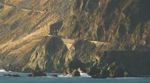 SUNSET OR SUNRISE ON AN EPIC HIGHWAY ALONG CLIFF FACE AND SEA SHORE Stock Footage 59070943