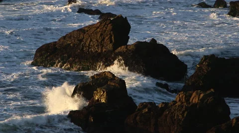 SUNSET OR SUNRISE LIGHT ON ROCKS AS OCEANS WAVES CRASH; MEDIUM Stock Footage 59070977