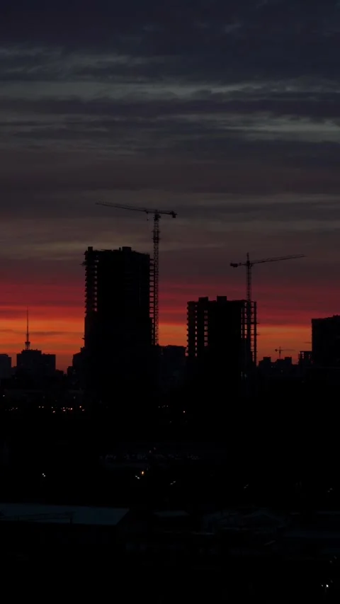 Sunset with orange and red sky in cityscape with silhouettes of buildings Stock Footage 260881061