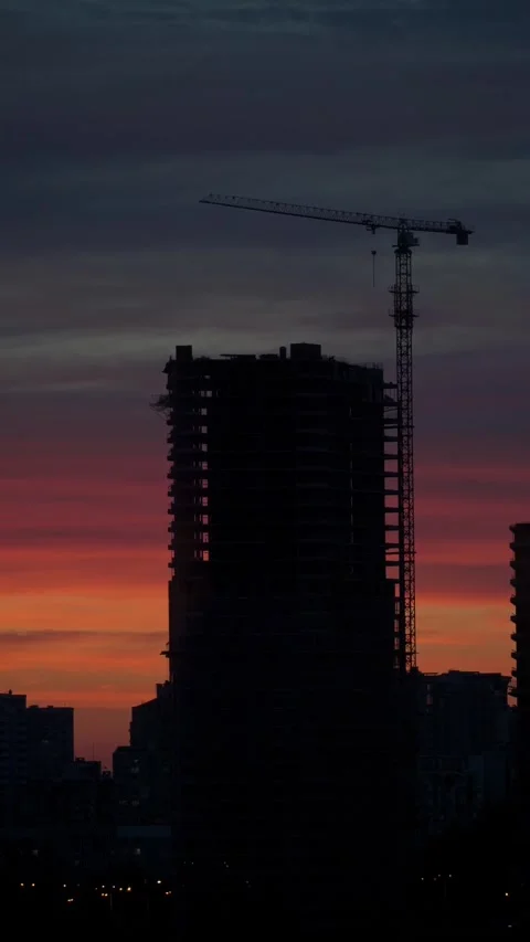 Sunset with orange and red sky in cityscape with silhouettes of buildings Stock Footage 260881179