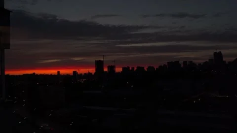 Sunset with orange and red sky in cityscape with silhouettes of buildings Stock Footage 260881215