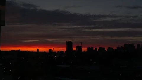 Sunset with orange and red sky in cityscape with silhouettes of buildings Stock Footage 260881230