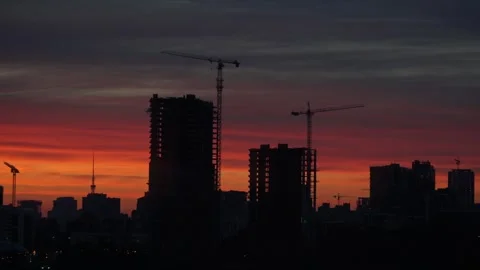 Sunset with orange and red sky in cityscape with silhouettes of buildings Stock Footage 260881233