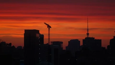 Sunset with orange and red sky in cityscape with silhouettes of buildings Stock Footage 260881235