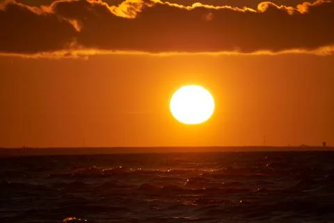 Sunset orange sky background at evening with clouds 库存照片