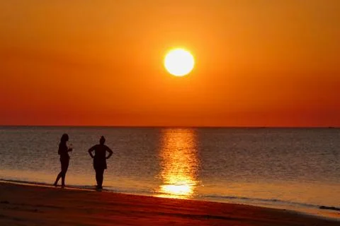 Sunset with orange sky at Nacpan beach with two girls, Palawan, Philippines Stock Photos