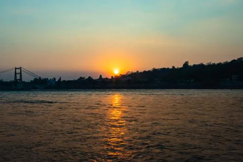 Sunset orange sky over flowing river horizon at evening from flat angle Foto stock