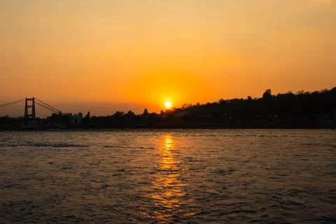 Sunset orange sky over flowing river horizon at evening from flat angle Foto stock