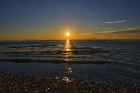 Sunset of an orange sun with 14 rays against Stock Photos