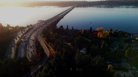 Sunset Over Aerial View of Bridge Leading to Suburban Neighborhood by the Lake	 Stock Footage 281802470