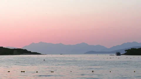 Sunset over the Albanian Riviera with calm sea and mountain silhouette Stock Footage 338591982