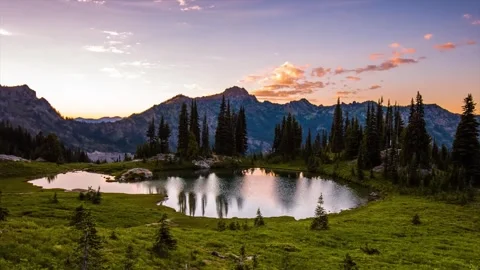 Sunset over an alpine lake on the Naches Peak Loop Trail in Mount Rainier Nation Stock Footage 332141623