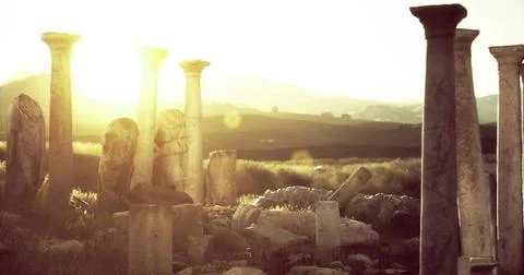 Sunset over ancient ruins with weathered columns and historical sculptures Stock Illustration