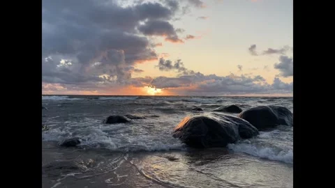 Sunset over the Baltic Sea with waves and coastal rocks Stock Footage 335543522