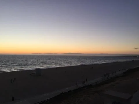 Sunset Over the Beach Casting Golden Hues on Waves and Sky Stock Photos