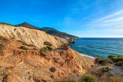 Sunset over beach, cliffs and hills and deep azure sea. Agios Ioannis beach Stock Photos