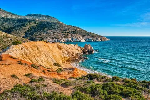 Sunset over beach, cliffs and hills and deep azure sea. Agios Ioannis beach Stock Photos
